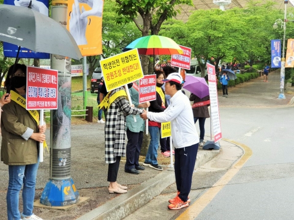 이천시민 한마음 걷기대회에 참석한 송석준 국회의원이 게릴라 피켓시위에 나선 양정 학부모들과 일일이 악수를 나누고 있다.