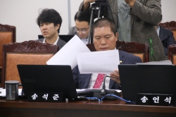 송석준 의원이 국정감사장에서 서류를 살펴보고 있다.